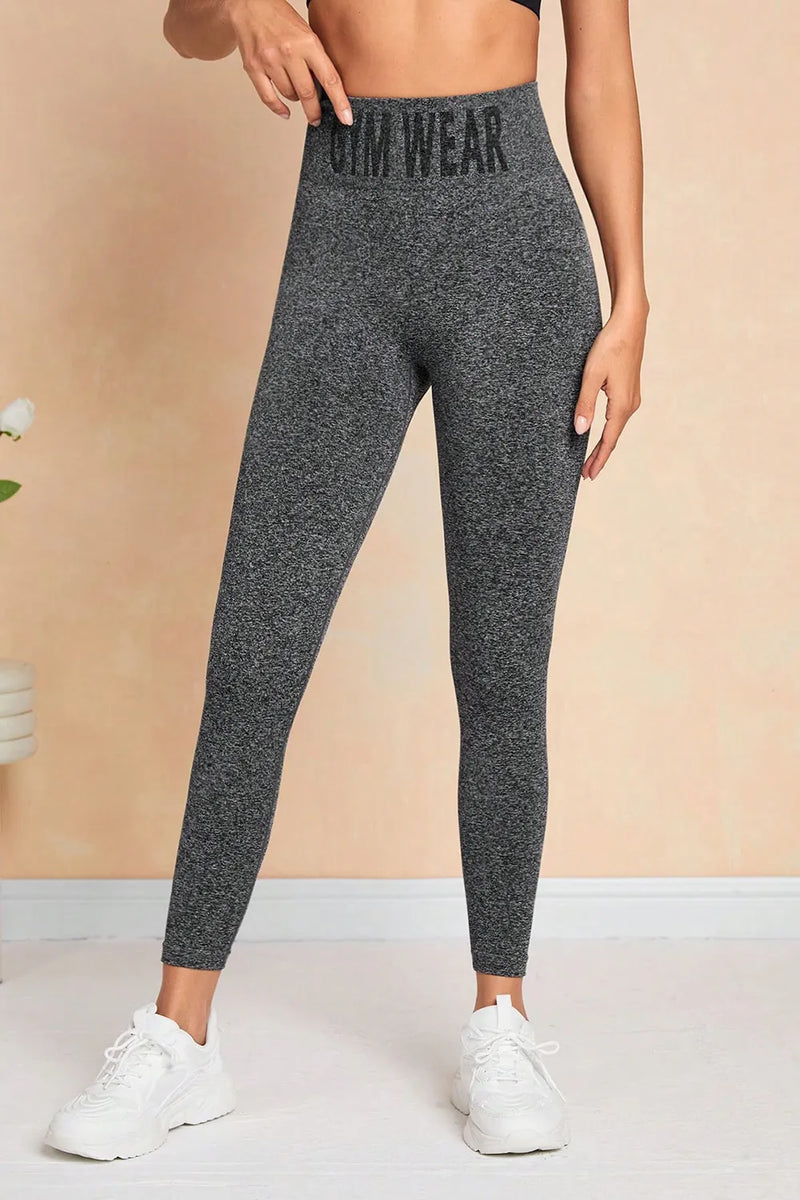 Person wearing gray leggings with 'Gym Wear' text on a beige background
