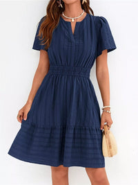 Woman wearing a blue dress against a white background