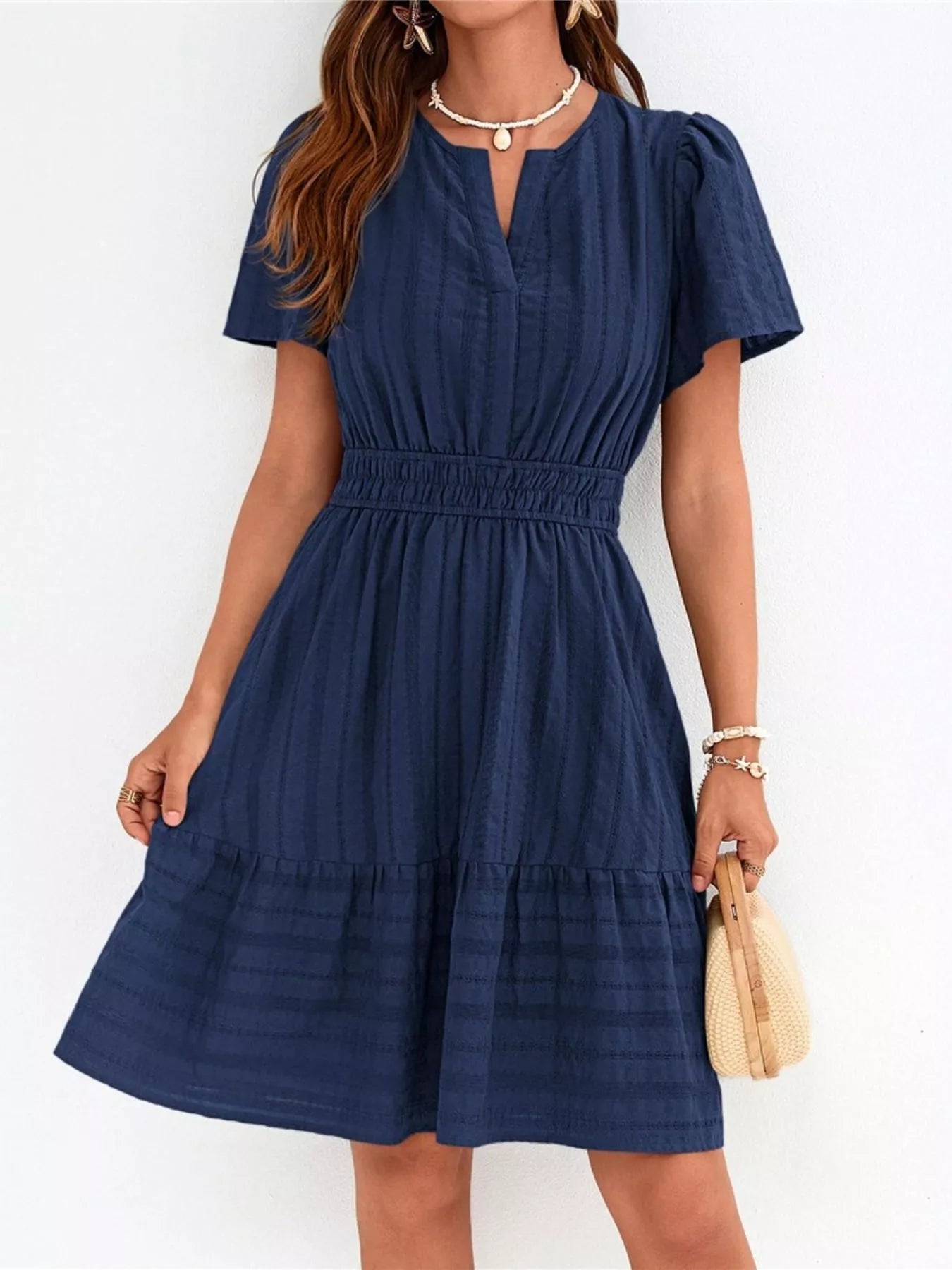 Woman wearing a blue dress against a white background