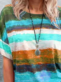 Person wearing a colorful striped shirt with a necklace featuring a large pendant.