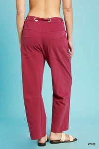 Wine-colored pants on a person against a blue background