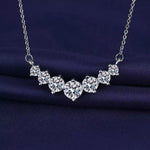 Silver necklace with clear gemstones on a dark blue fabric background