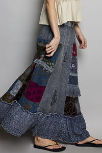 Person wearing a patchwork skirt with a plain background