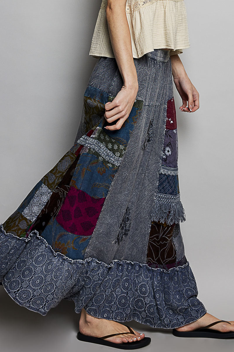 Person wearing a patchwork skirt with a plain background
