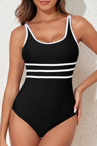 Black swimsuit with white stripes worn by a model against a neutral background