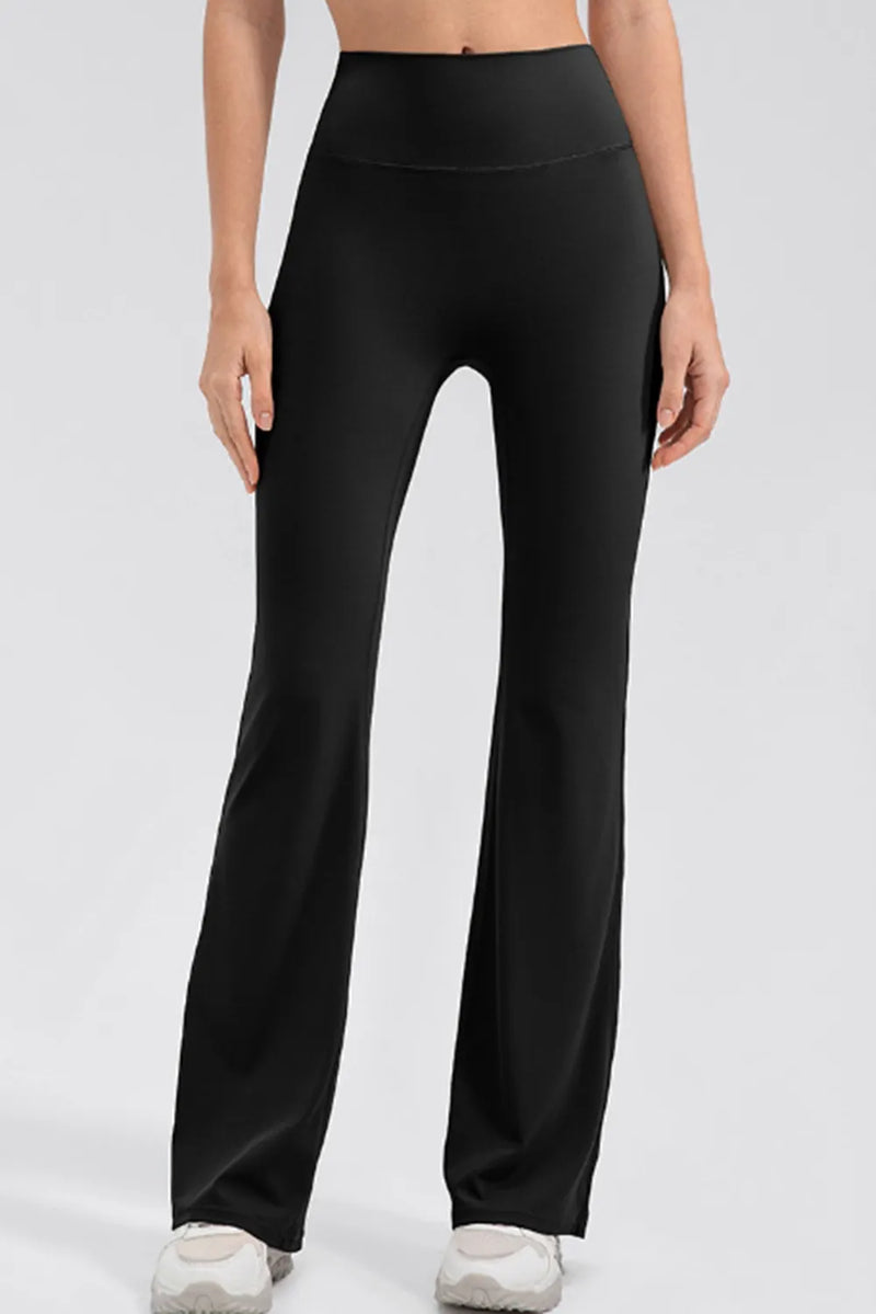 Person wearing black high-waisted pants on a white background