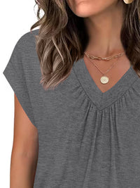Gray short-sleeve top worn by a person, with a focus on the neckline and shoulders.