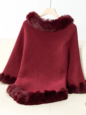 Red poncho with fur trim on a white background