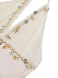 Close-up of a decorative fabric edge with beads and sequins on a white background