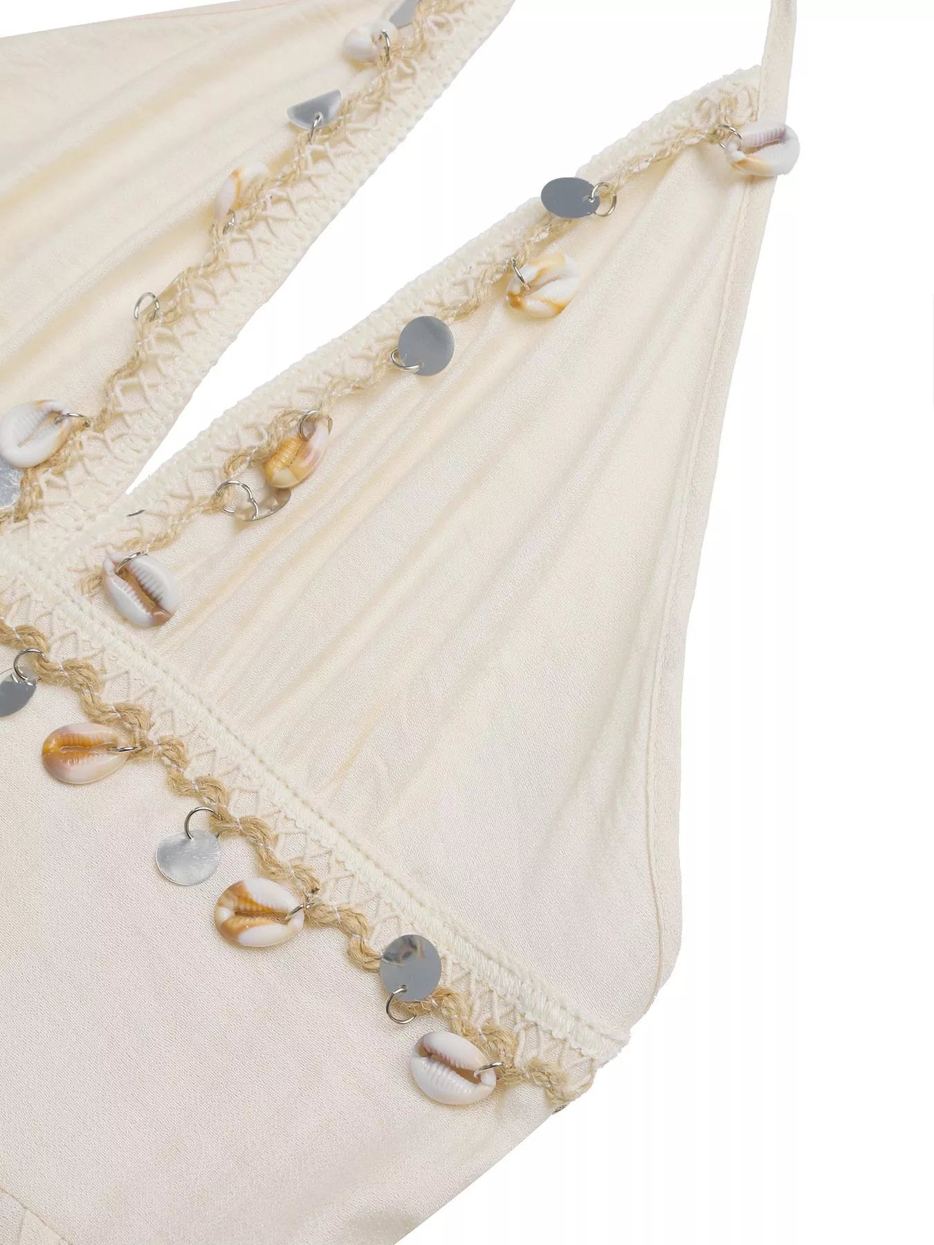 Close-up of a decorative fabric edge with beads and sequins on a white background