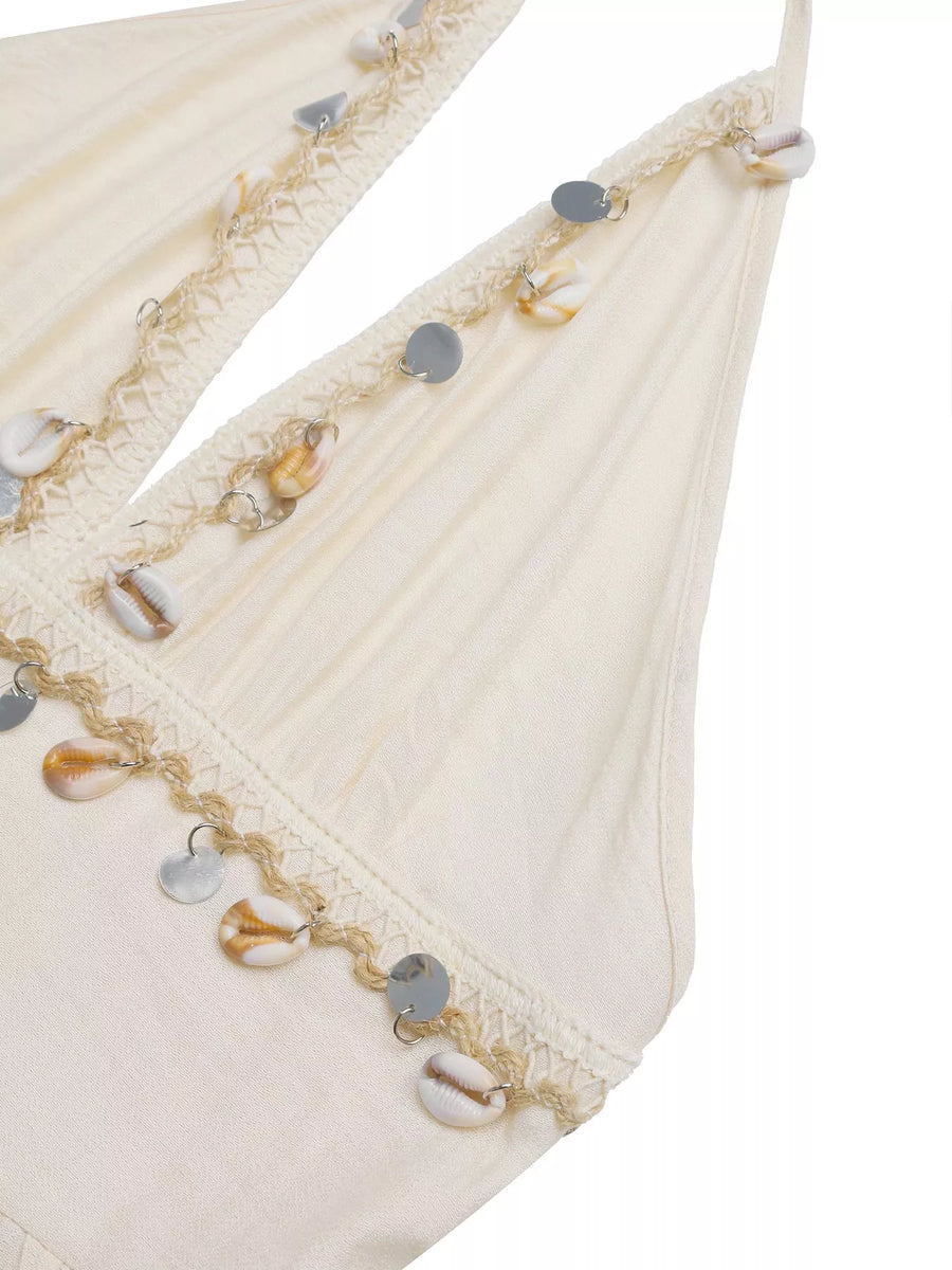 Close-up of a decorative fabric edge with beads and sequins on a white background