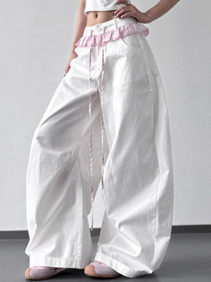 White wide-leg pants with pink waistband and trim on a plain background