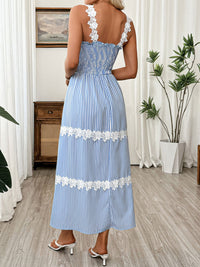 Woman wearing a blue and white striped dress with floral details in a room.