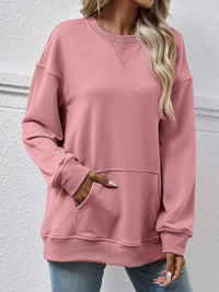 Person wearing a pink sweatshirt with a plain background