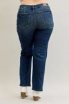 Blue jeans worn by a person on a plain background