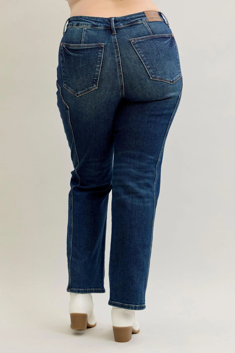 Blue jeans worn by a person on a plain background