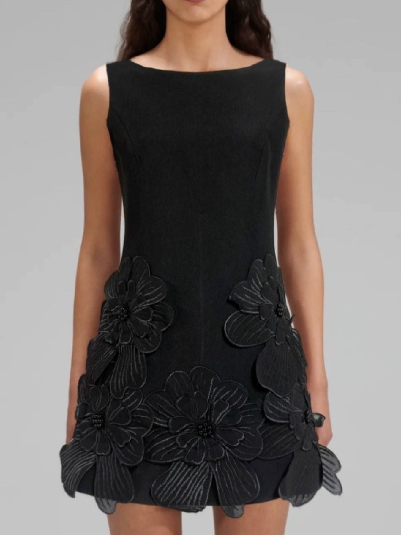 Black dress with floral embellishments on a gray background