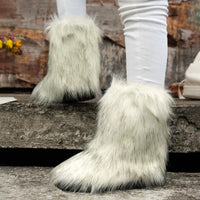 White furry boots worn with white leggings on a stone step.