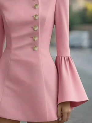 Close-up of a pink dress with bell sleeves and decorative buttons.