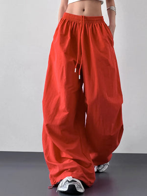 Red wide-leg pants worn by a person on a plain background