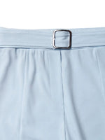 Light blue pants with a silver belt buckle on a white background