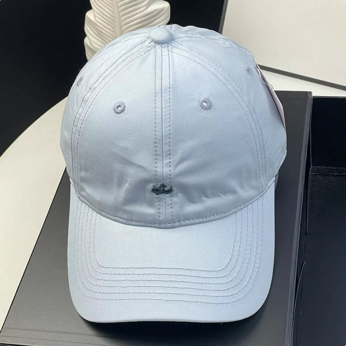 Light blue baseball cap on a dark surface with a blurred background
