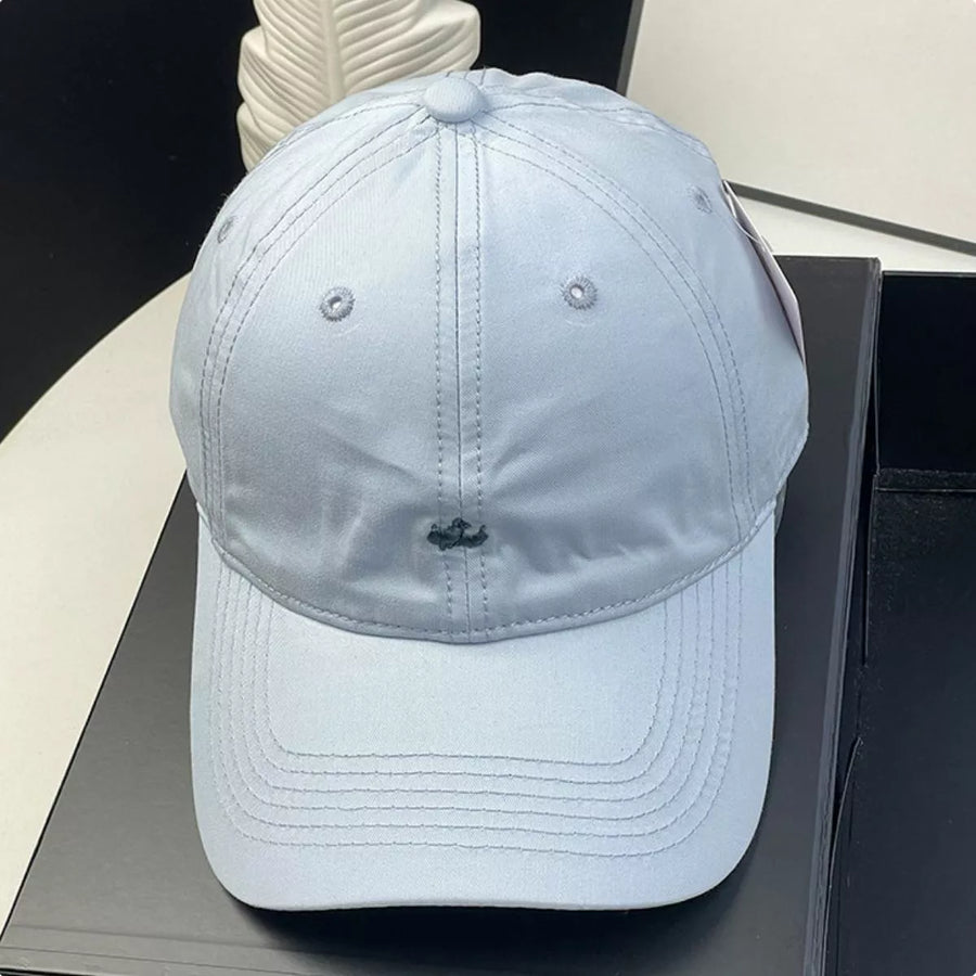 Light blue baseball cap on a dark surface with a blurred background