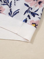 Close-up of a floral patterned fabric with pink and blue flowers on a beige background