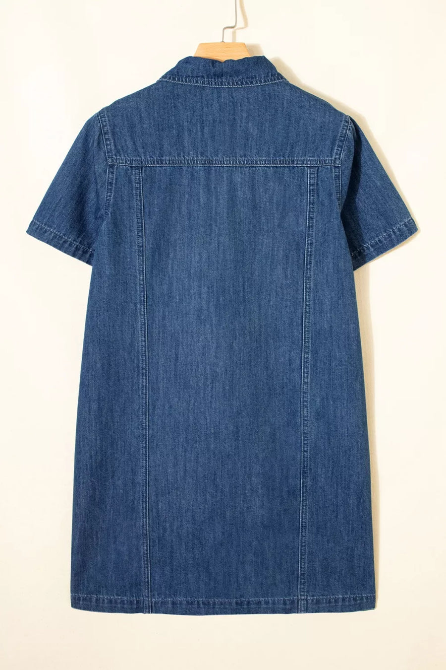 Blue denim dress on a hanger against a white background
