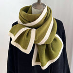 Green and white knitted scarf on a mannequin against a white background