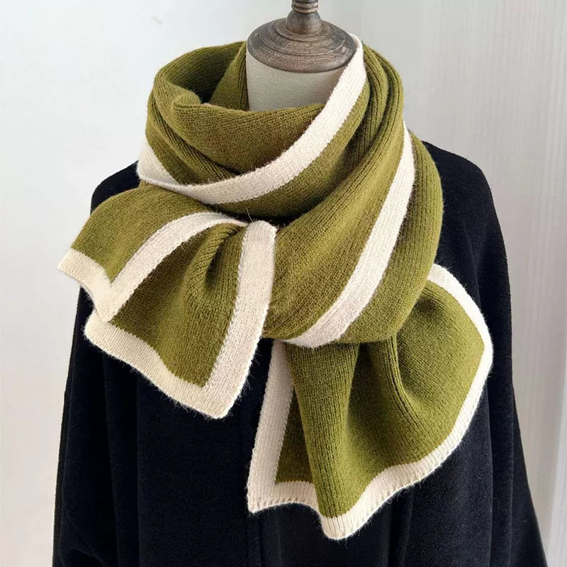 Green and white knitted scarf on a mannequin against a white background