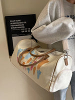 Person holding a white bag with cat illustrations against a neutral background