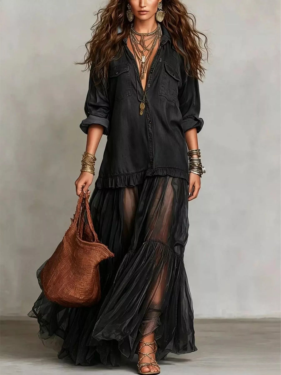 Woman wearing a black outfit with sheer layers, holding a brown leather bag against a neutral background.