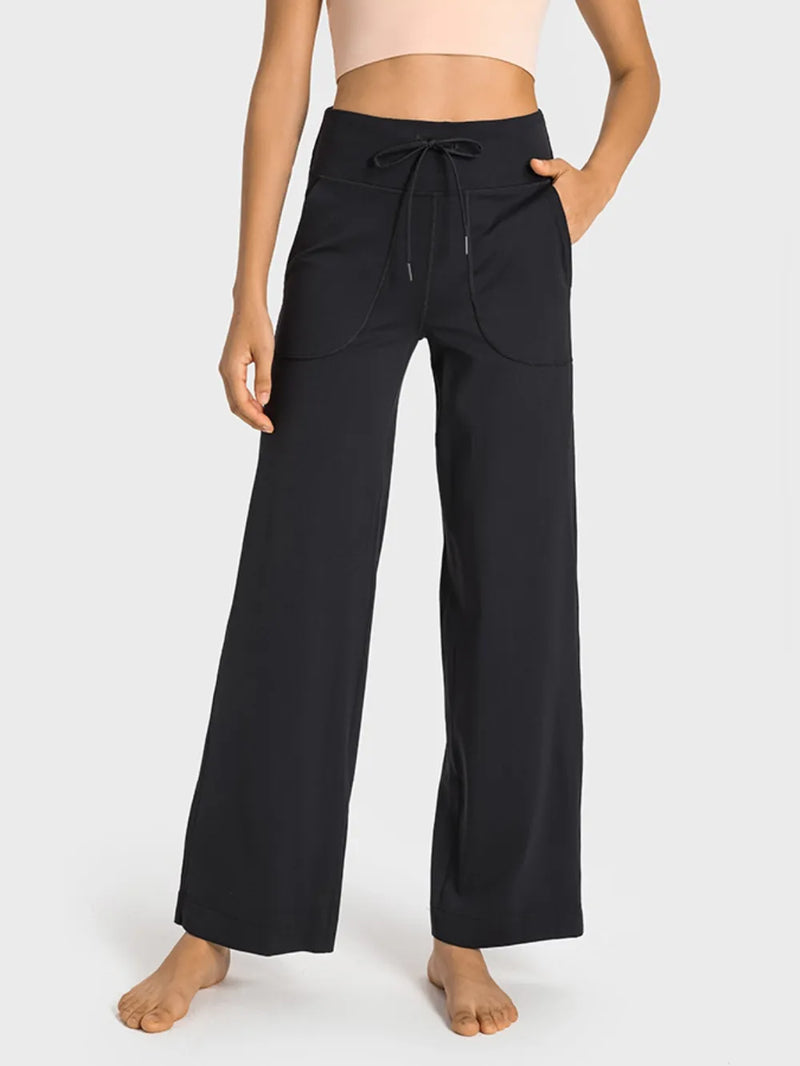Person wearing black wide-leg pants on a white background