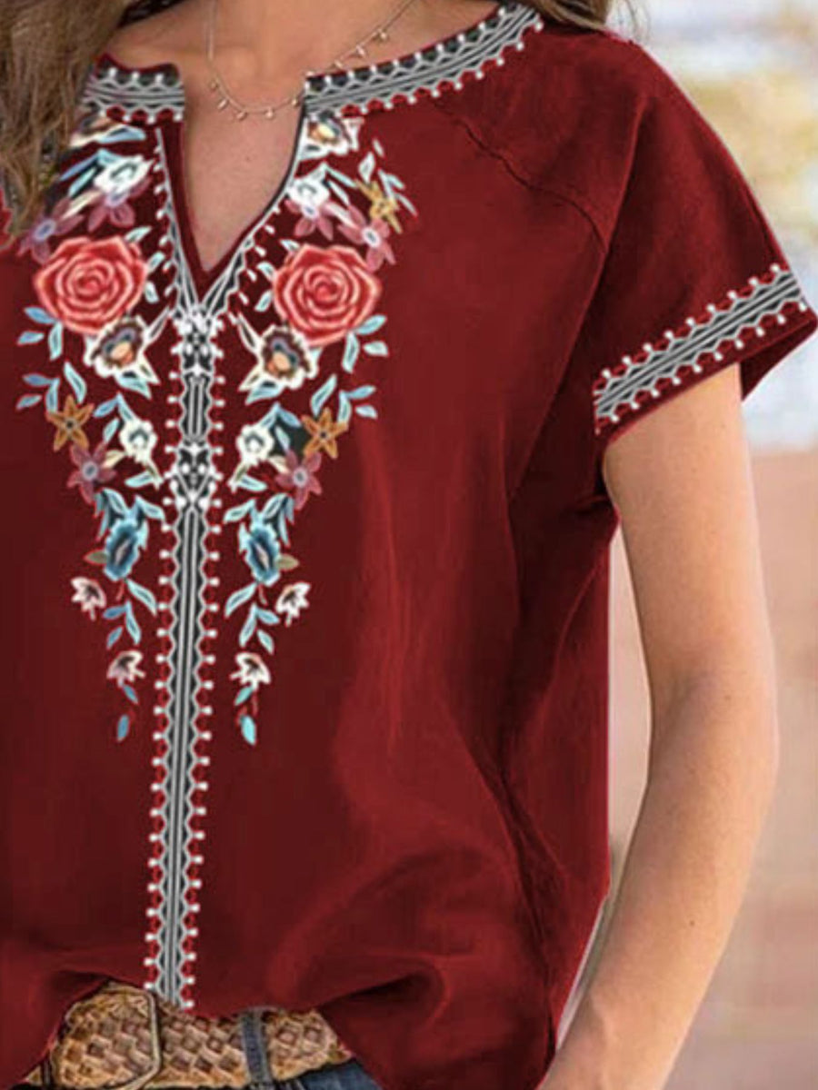 Red embroidered top with floral patterns on a blurred background