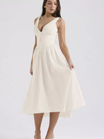 Woman wearing a white dress on a plain background