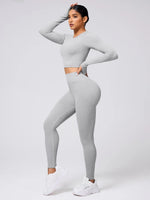 Woman wearing a gray athletic outfit on a white background