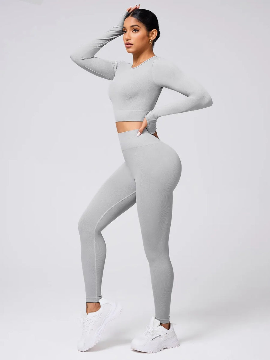 Woman wearing a gray athletic outfit on a white background