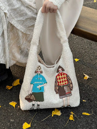 White fluffy bag with embroidered characters on a pavement.