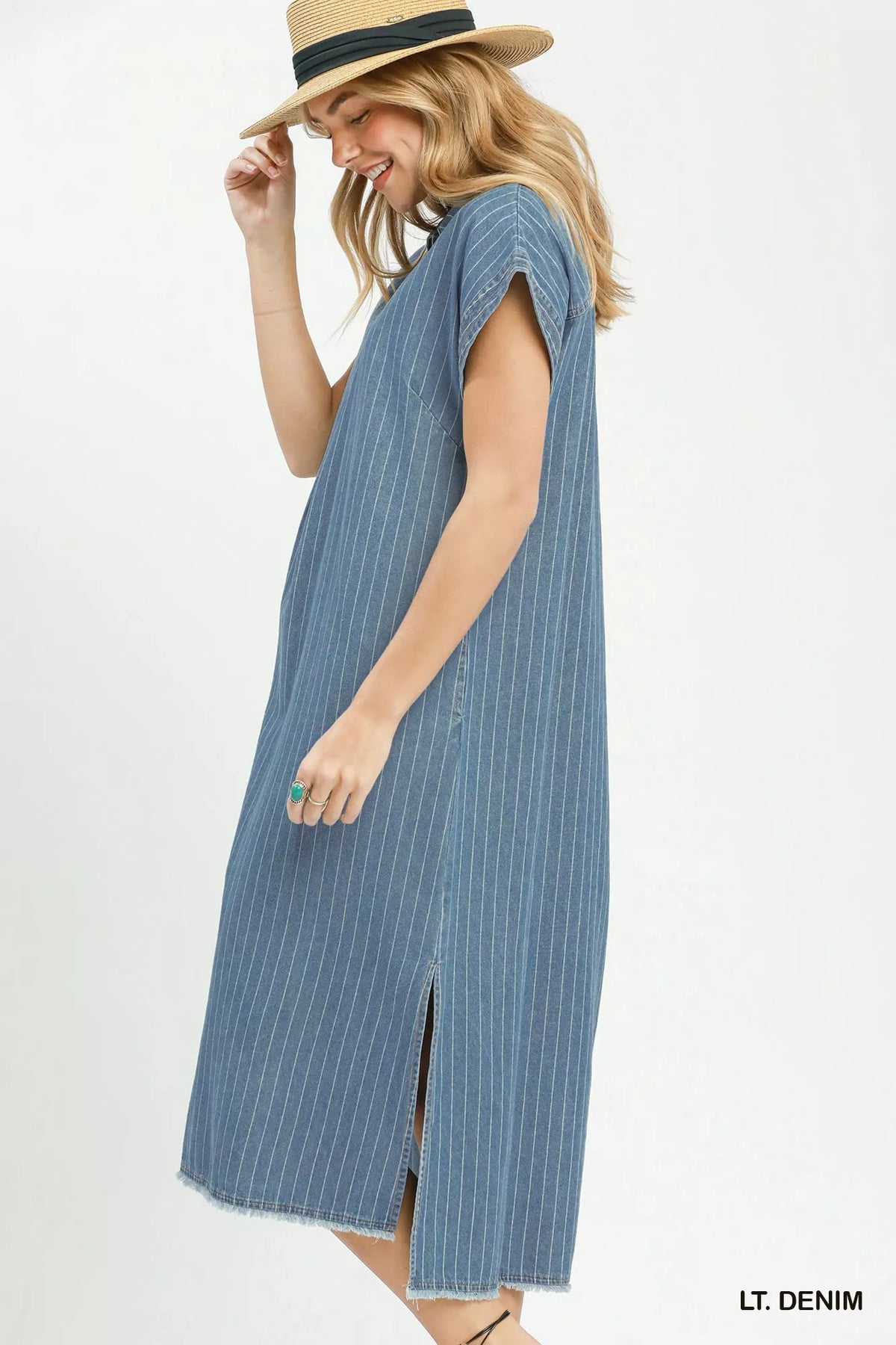 Woman wearing a light denim dress with a white background