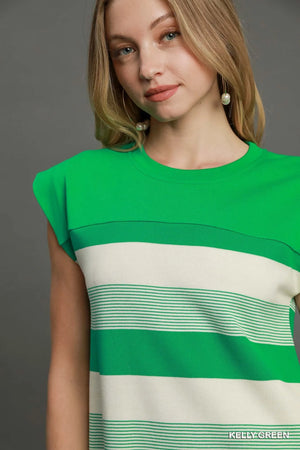 Woman wearing a green and beige striped dress against a gray background