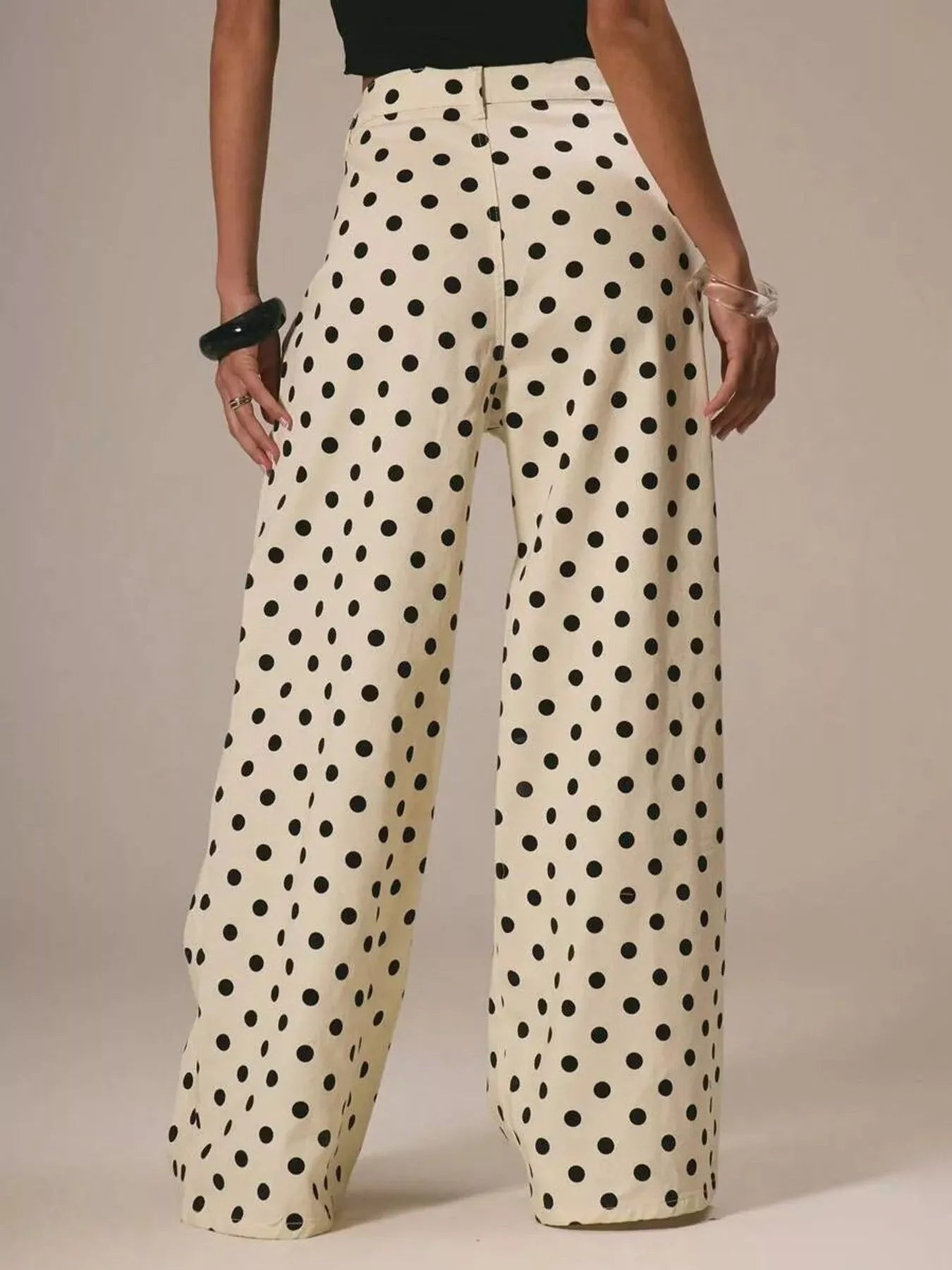 Polka dot pants worn by a person on a neutral background