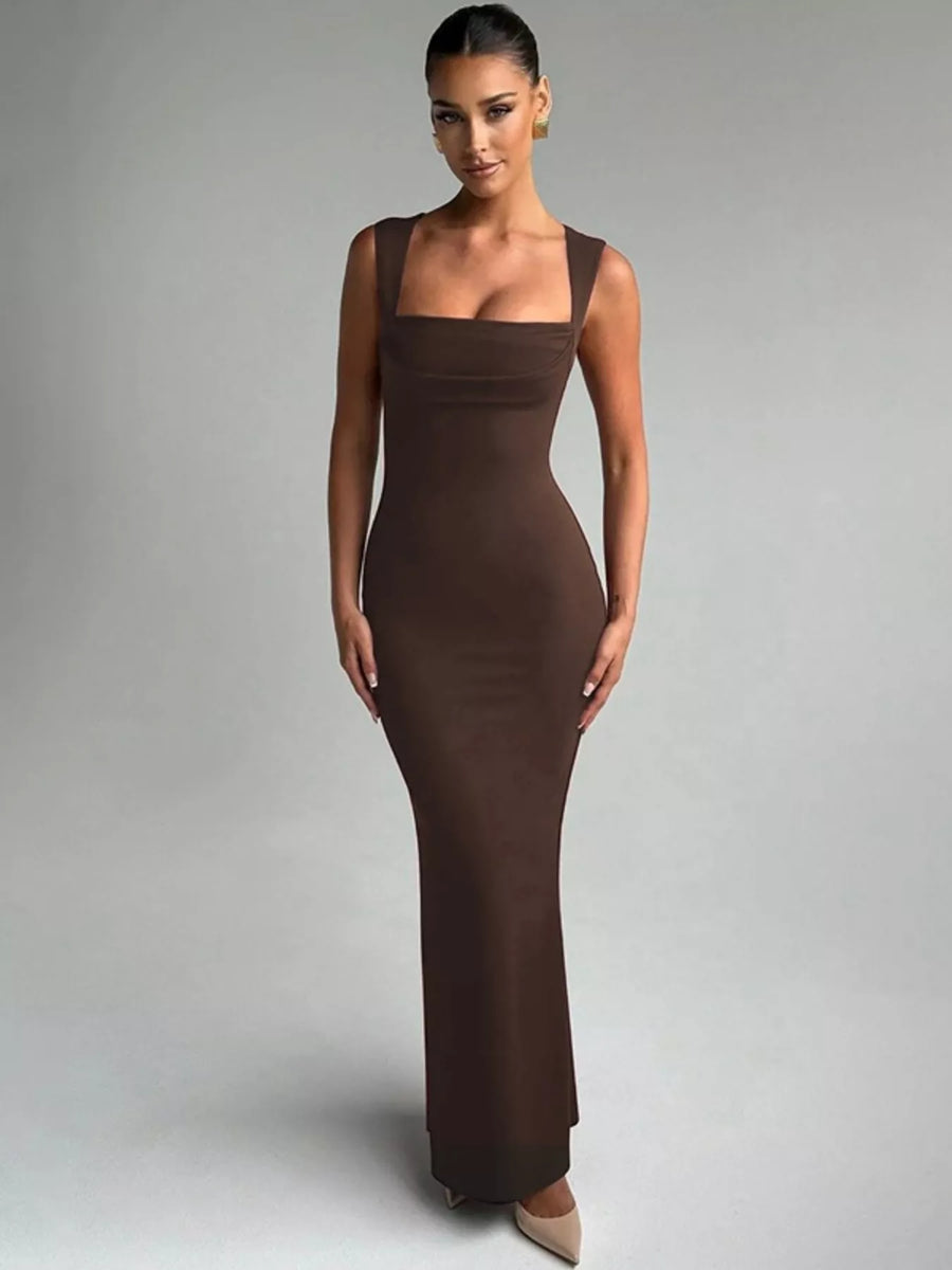Woman wearing a brown evening gown against a gray background