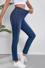 Person wearing blue jeans and white sneakers on a white background