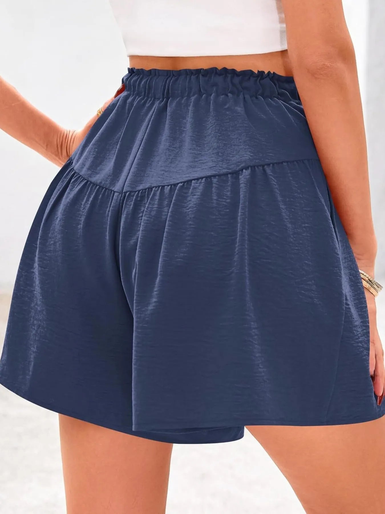 Navy blue shorts worn by a person on a white background
