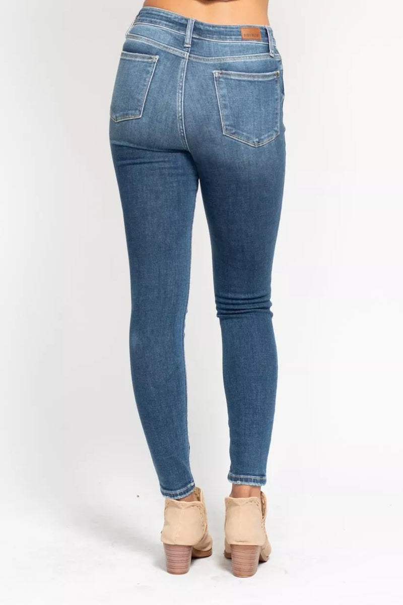 Blue jeans worn by a person on a white background