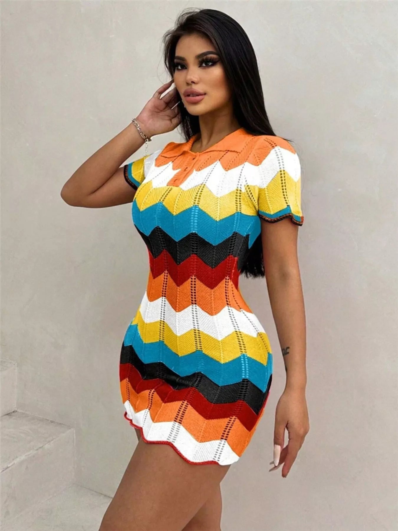 Woman wearing a colorful striped dress against a plain background