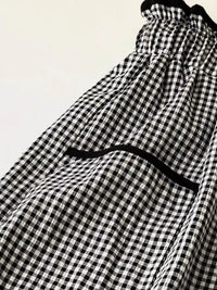 Black and white checkered pants with a black waistband on a light background
