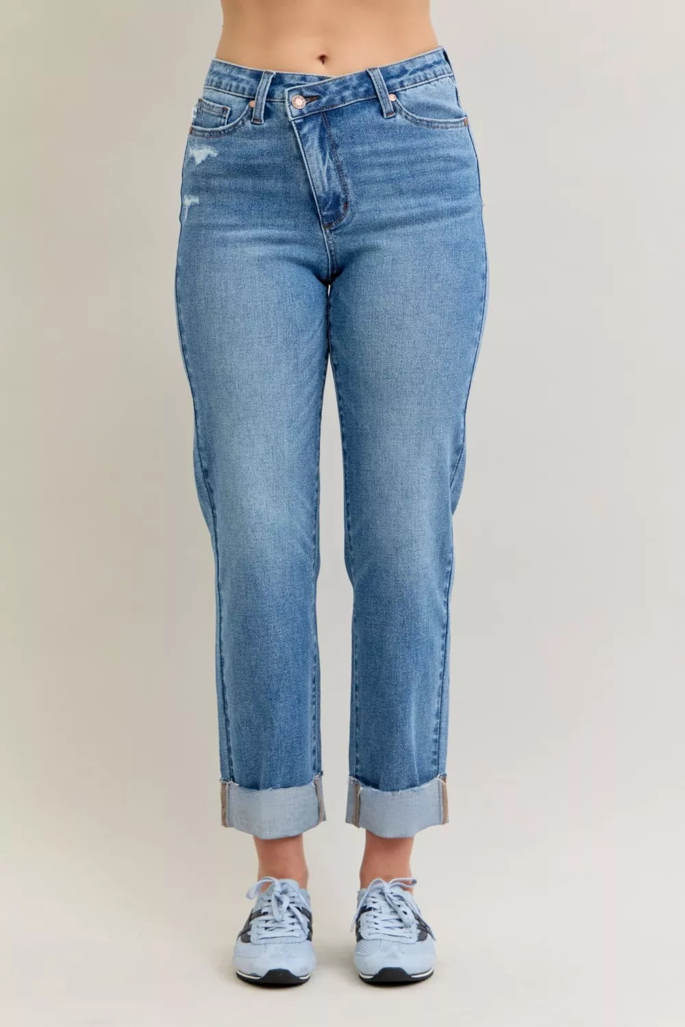 Blue jeans worn by a person on a plain background