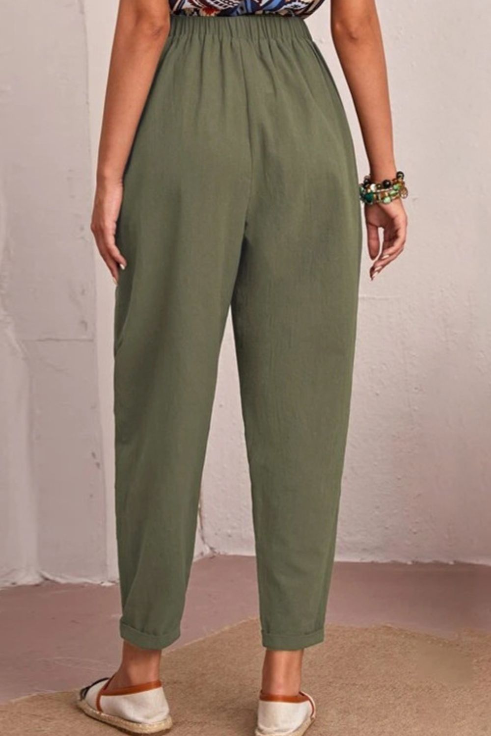 Person wearing olive green pants against a plain background